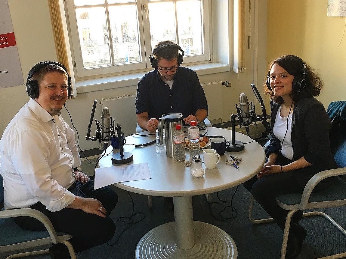 Blick in das Podcast-Studio mit Hosts und Gast Delara Burkhard