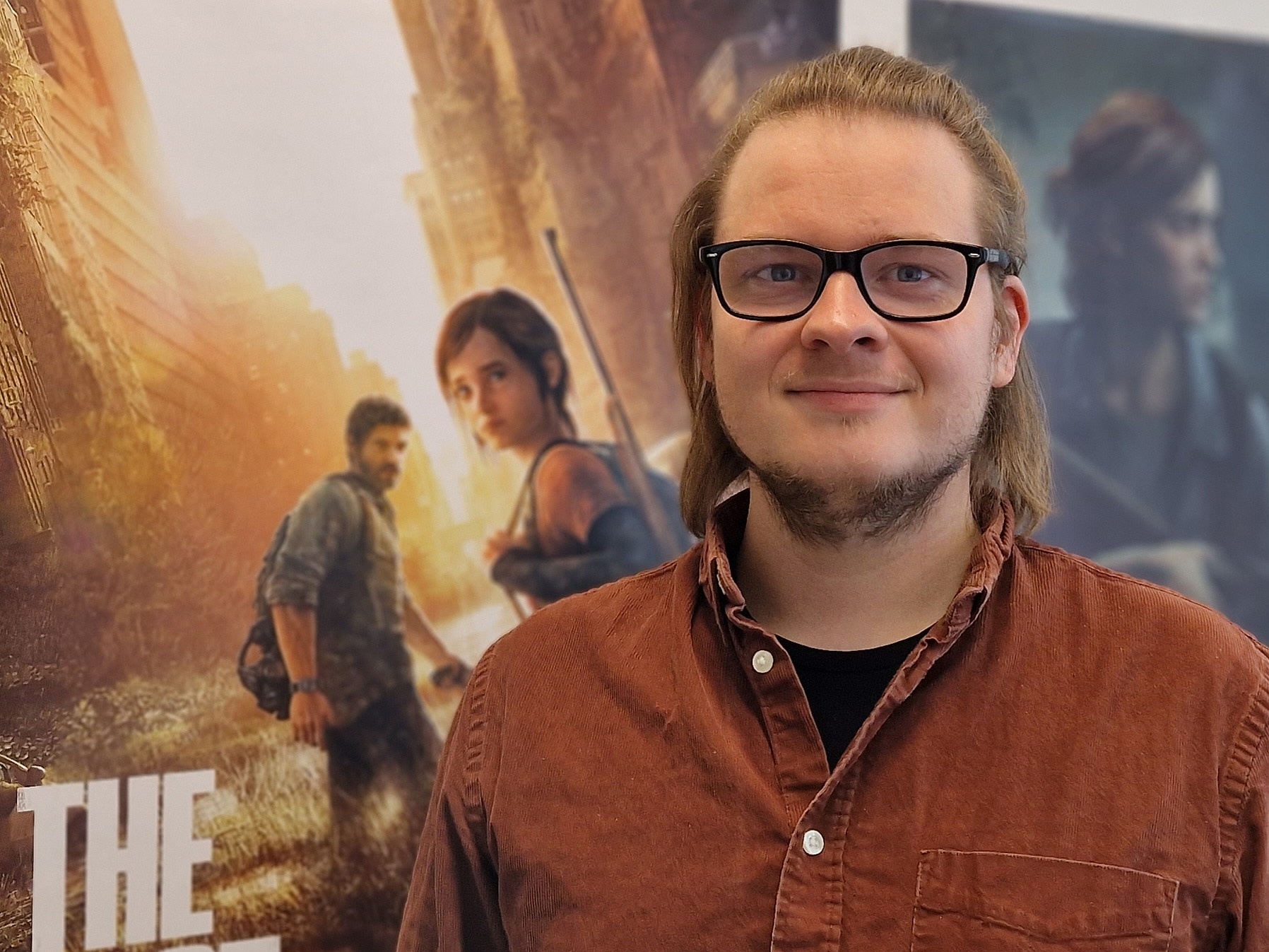 Christoph Lahusen in seinem Büro vor den Plakaten zu dem Videospiel The Last of Us Part 1 und The Last of Us Part 2