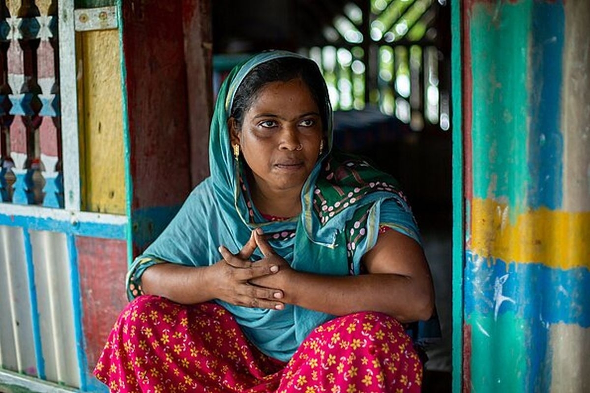 Khadija aus Bangladesh sitzt vor ihrer Hütte und berichtet von ihrer durch Salzwasser hervorgerufenen Gebärmutterinfektion