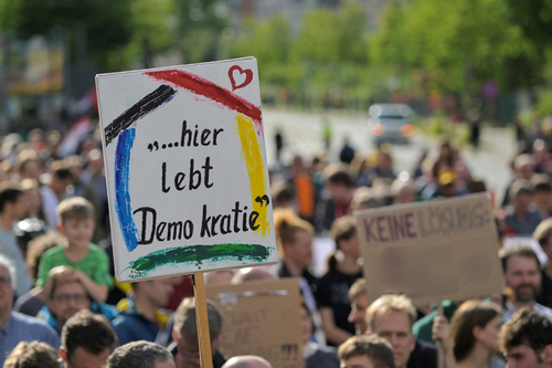 Demonstranten mit Plakat "Hier lebt Demokratie"