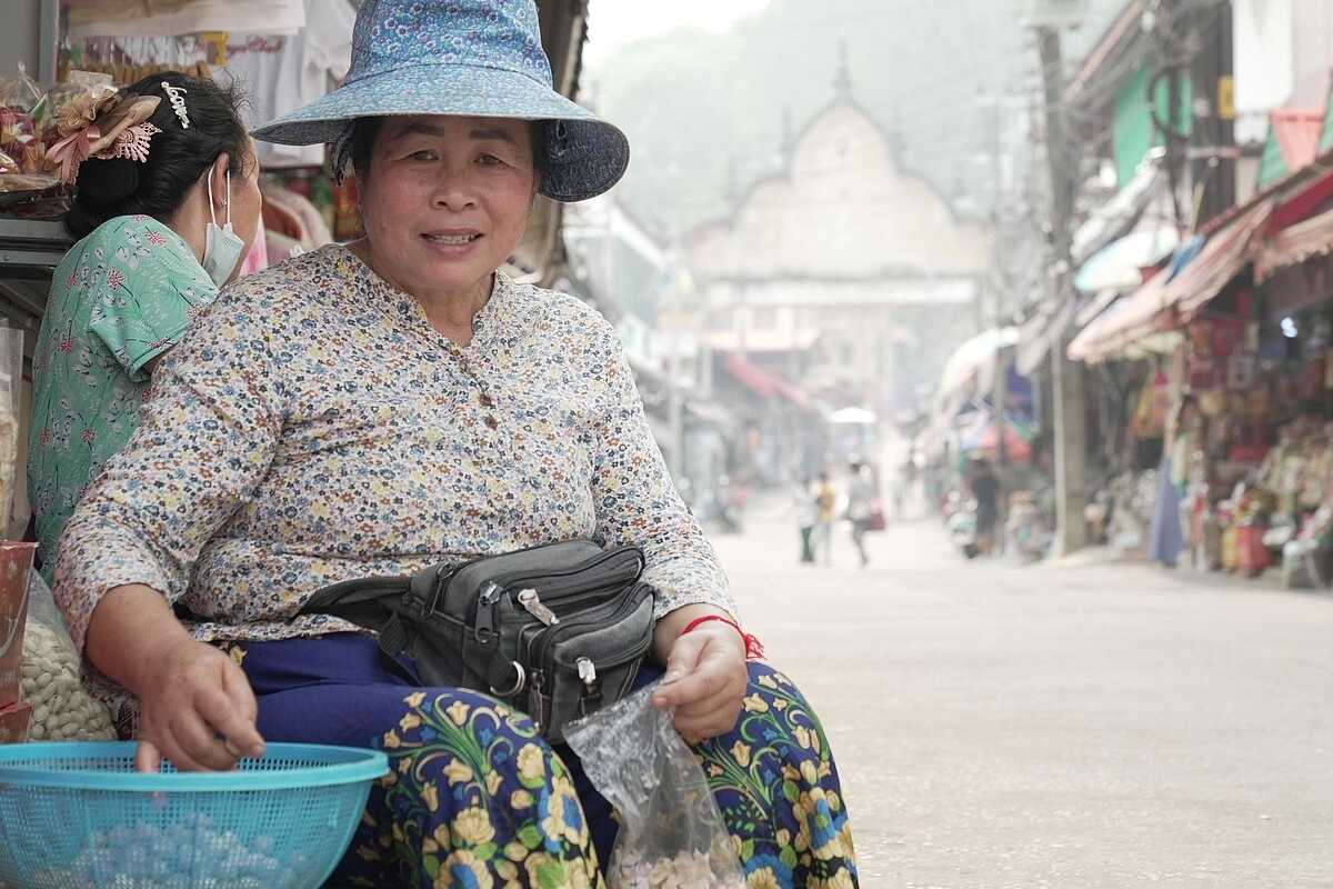 Eine der örtlichen Verkäuferinnen auf dem Markt im Bezirk Mae Sai lächelt in die Kamera, ohne ihre Maske aufzusetzen. Sie sagte dem Fotografen, dass sie sie normalerweise wegen der schmutzigen Luft trägt, nur heute nicht. 