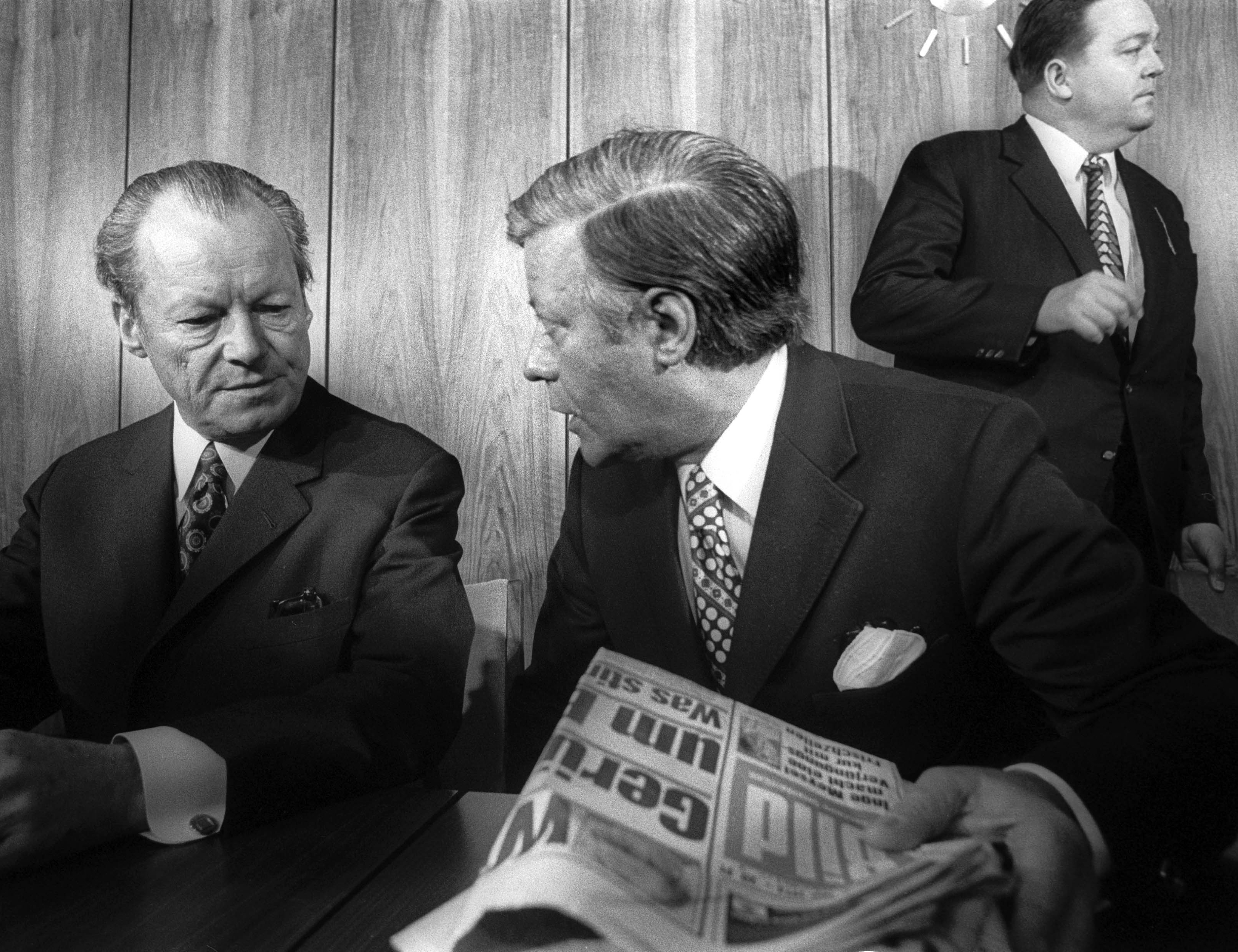 Helmut Schmidt und Willy Brandt, im Hintergrund Holger Börner stehend