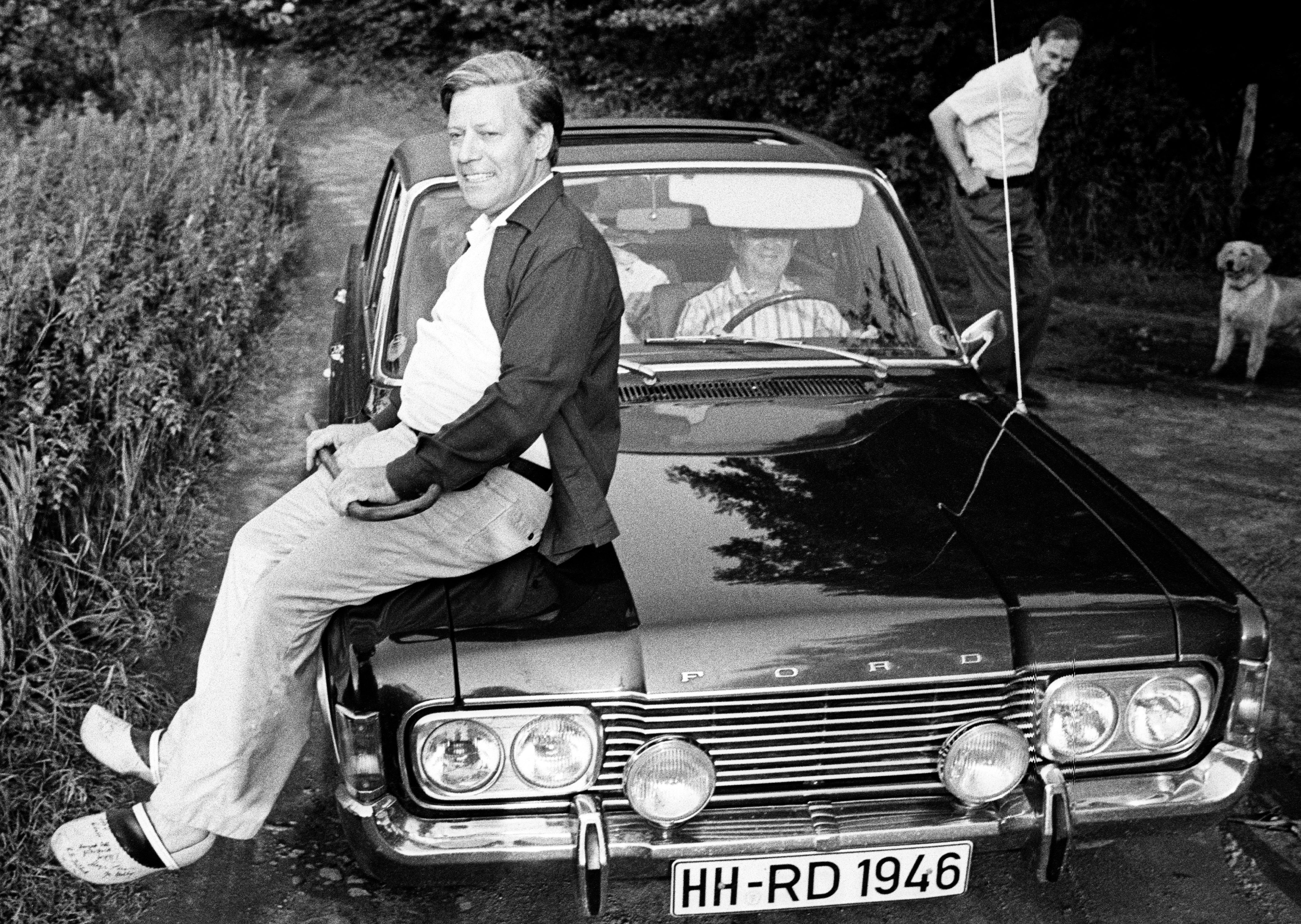 Helmut Schmidt auf der Motorhaube eine Ford Taunus sitzend