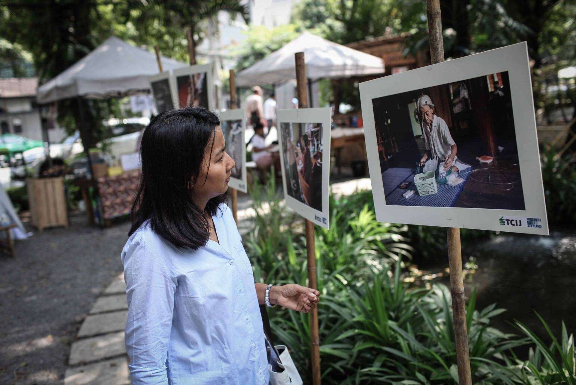 Junge Thailänderin betrachtet Bilder der FES zu Mae Moh in Thailand an