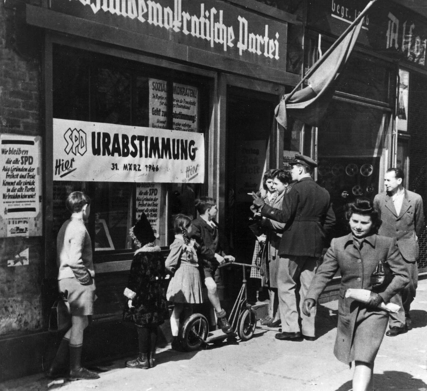 Personen und Banner vor dem Parteibüro der SPD zur Urabstimmung der West-Berliner SPD am 31.3.1946. Rechte: Rechteinhaber nicht ermittelbar. Quelle: AdsD, 6/FOTB001836.