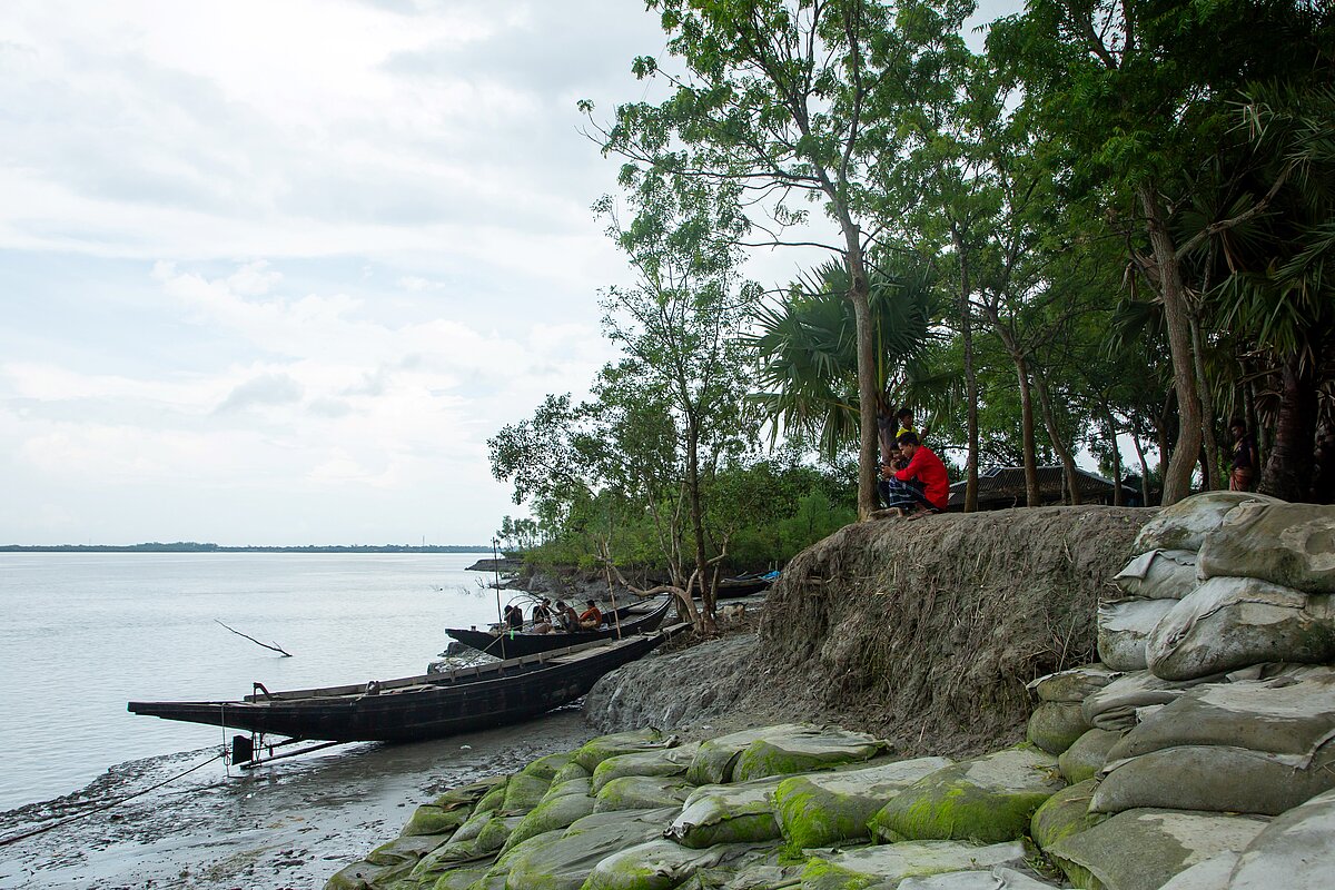 Kleine Boote vor einer durch Tropenstürme erodierten Küste in Bangladesch