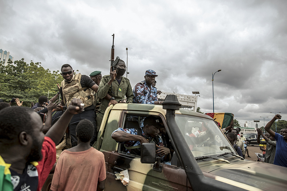 Militärputsch in Mali. Bewaffneter Männer auf einem Militärfahrzeug, die von der Menschenmenge umjubelt wird