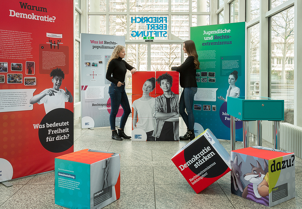 Zwei junge Frauen stehen im Eingang der FES Bonn und schauen sich die Ausstellung an