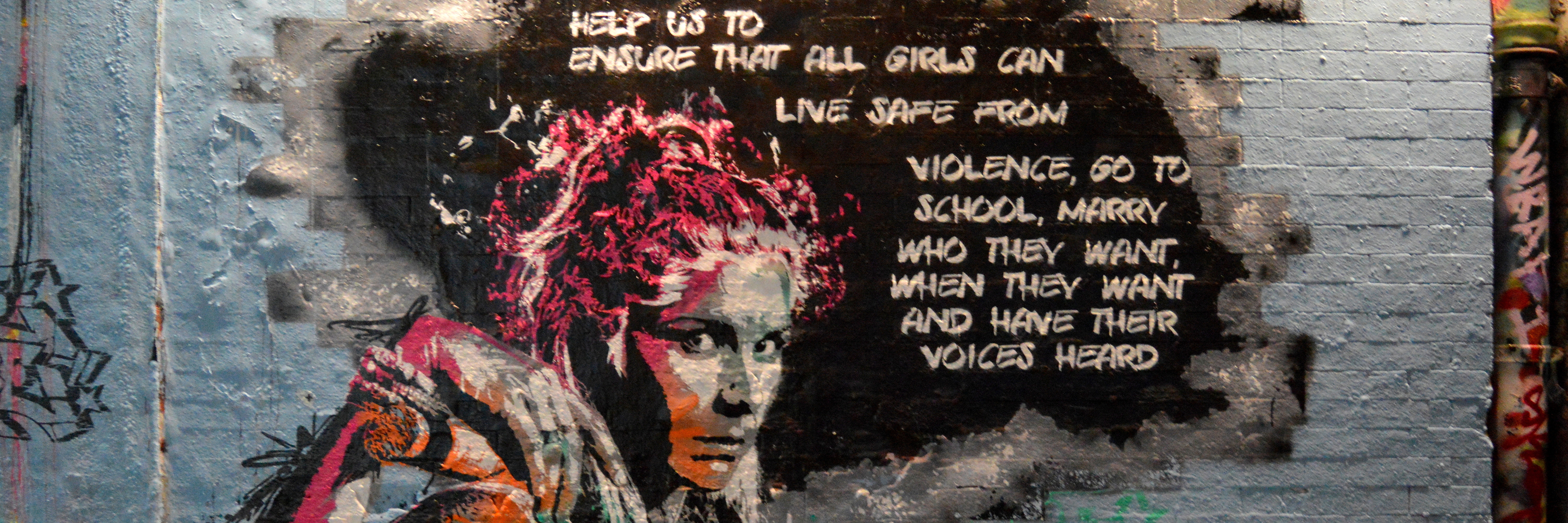 Foto: Graffititi, das eine Frau mit Blick auf Betrachter_in zeigt  