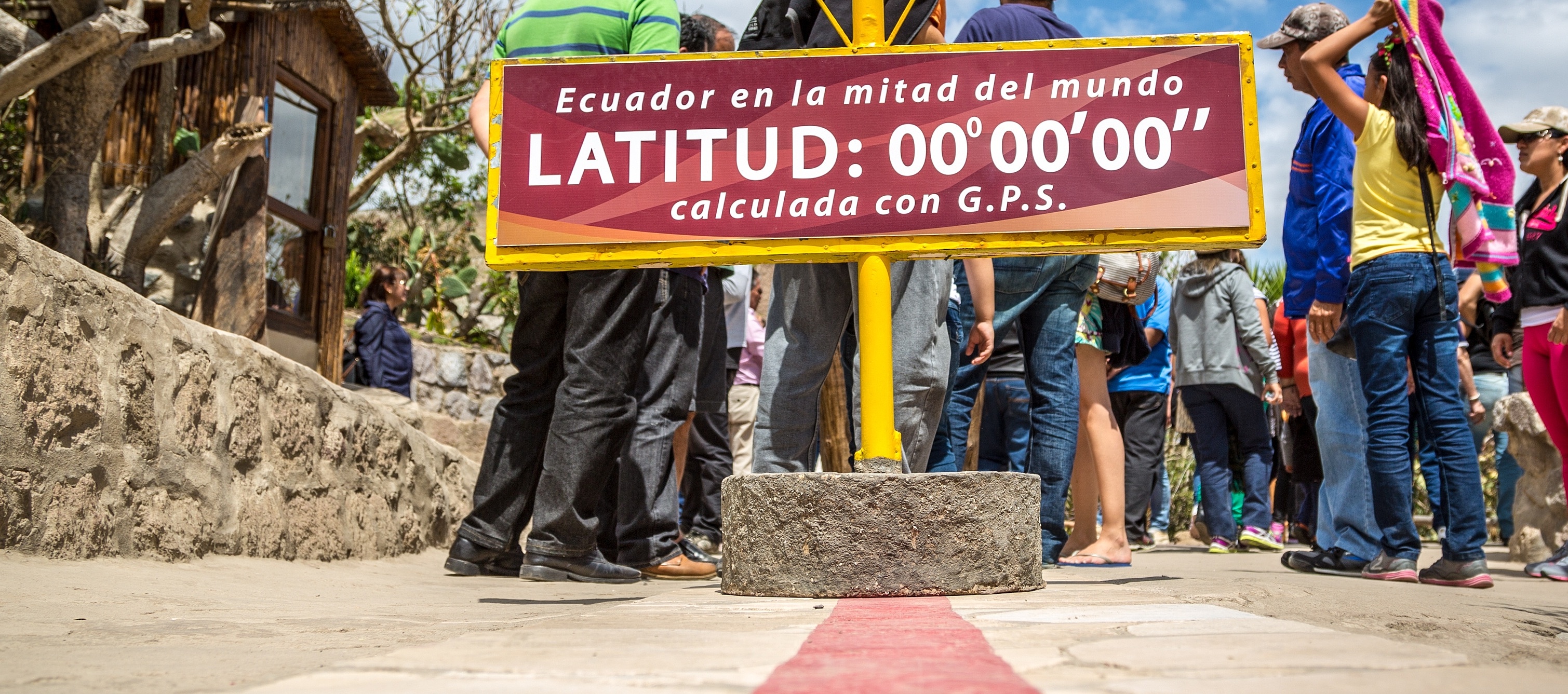 Rote Linie, ein Schild steht darauf mit der Schrift „La Mitad del Mundo“ - „Die Mitte der Welt“, Äquator in San Antonio de Pichincha, Ecuador