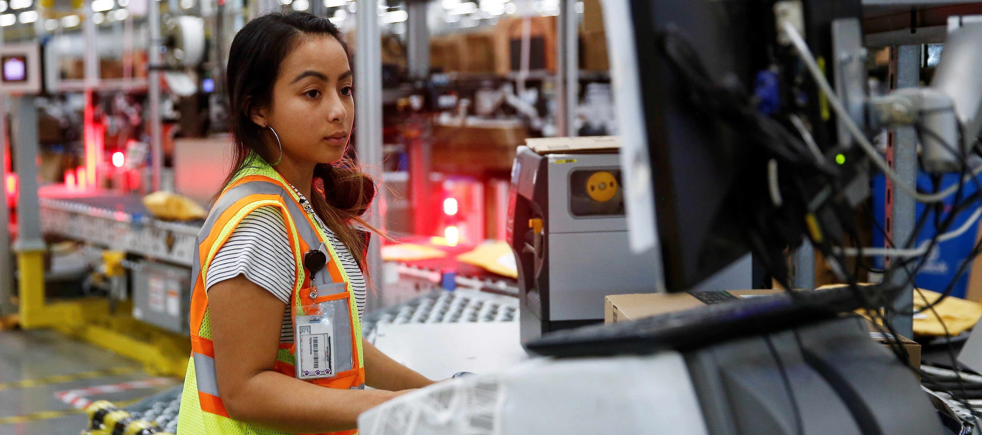 Amazon employee works on processing packages in Kent, Washington DC, REUTERS, 
