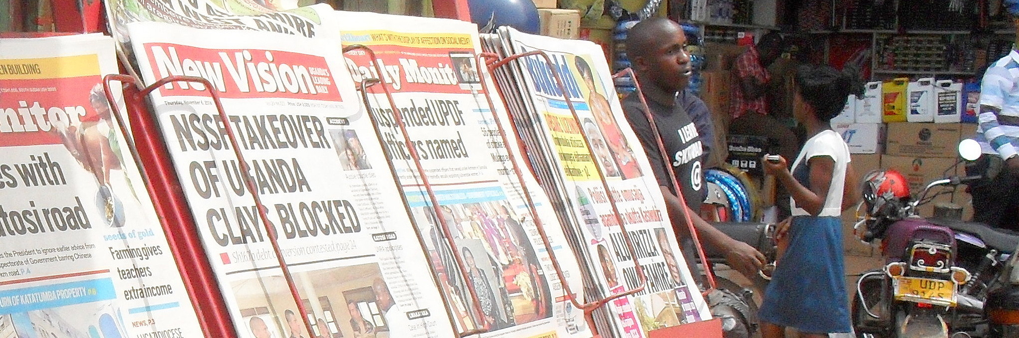 Junger Zeitungsverkäufer vor seinem Kiosk
