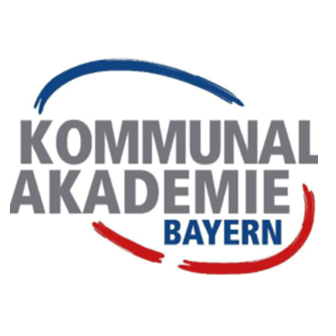 Logo der FES Kommunalakademie Bayern. In grauer Schrift: Kommunalakademie. Darunter in blauer Schrift das Wort "Bayern". Die Schrift wird oben von einem blauen Halbkreis und unten von einem roten Halbkreis umrahmt.