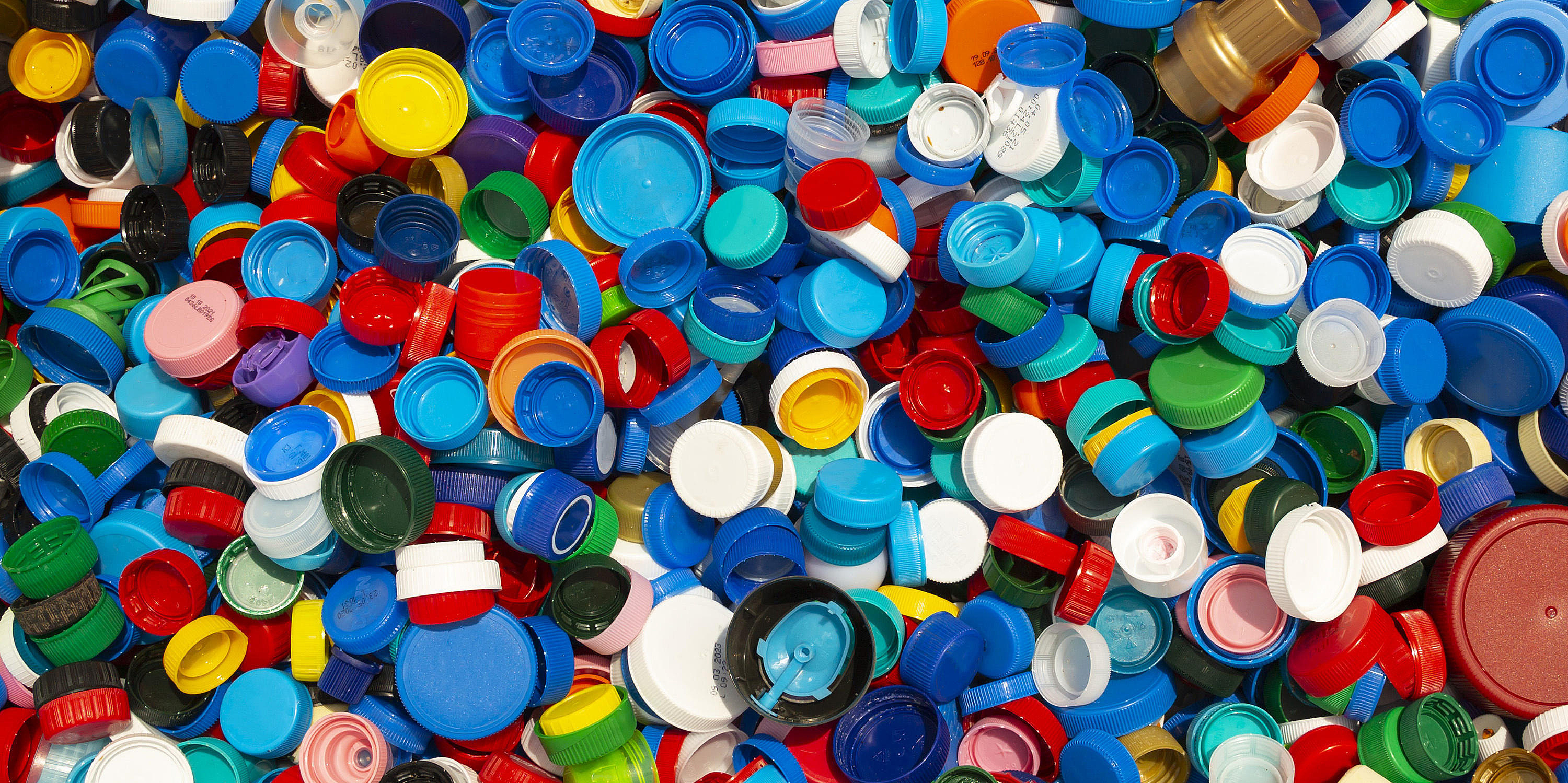 Tausende von bunten Kunststoffkappen werden zum Recycling gestapelt.