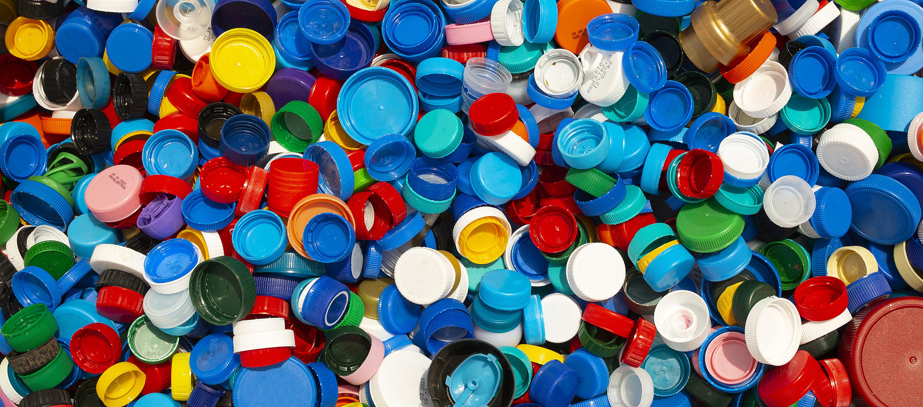 Tausende von bunten Kunststoffkappen werden zum Recycling gestapelt.