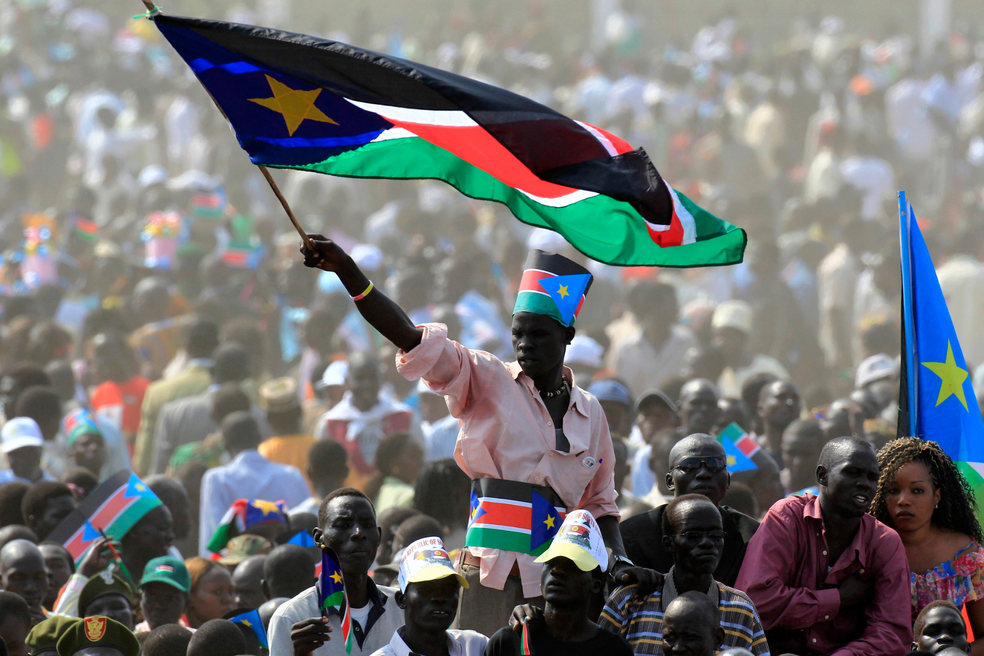 Ein Mann schwenkt die Flagge Südsudans während der Unabhängigkeitsfeierlichkeiten in der Hauptstadt Juba am 09. July 2011 umringt von einer großen Menge Feiernder. 