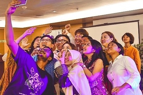 Lächelnde junge Asiaten*Innen verschiedener Nationalitäten bei einem Selfie