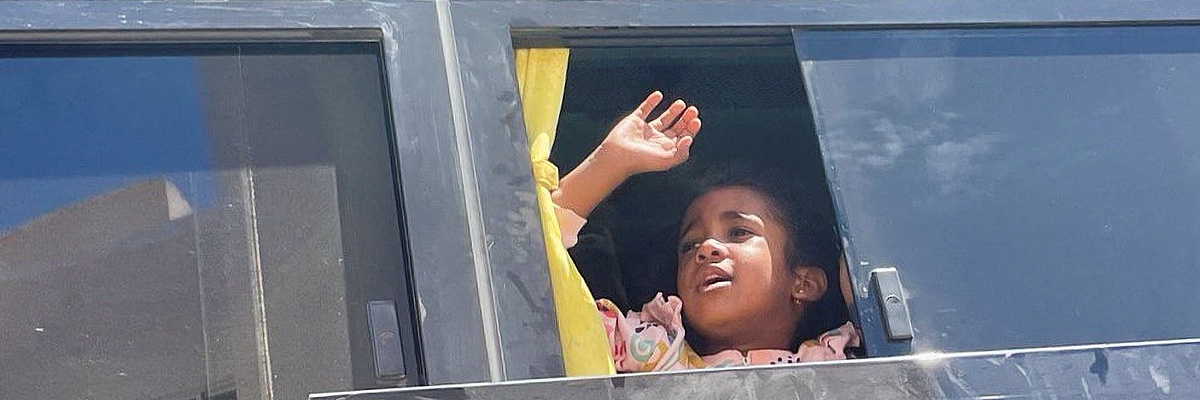 Winkendes Mädchen im Bus bei der Evakuierung im Sudan