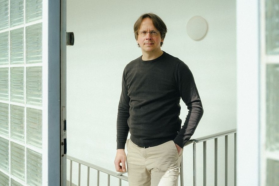 Jan-Robin Schäfer, Koordinator der Smart City Innovation Unit vor weißer Wand in einem Treppenhaus