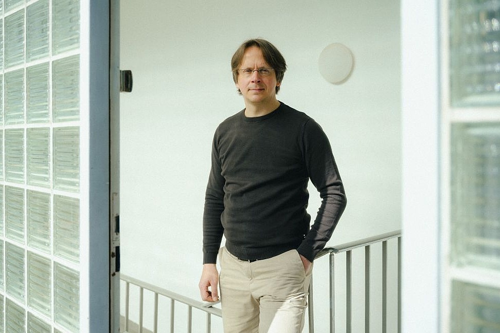 Jan-Robin Schäfer, Koordinator der Smart City Innovation Unit vor weißer Wand in einem Treppenhaus