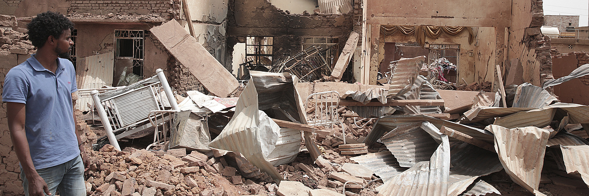A man walks by a house hit in recent fighting in Khartoum, Sudan, Tuesday, April 25, 2023.