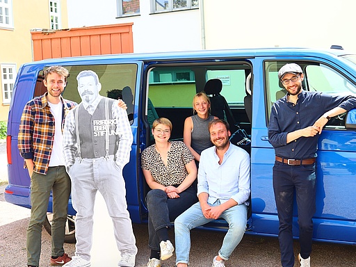 Fünf Personen mit Pappaufsteller von Friedrich Ebert vor dem FES-Mobil