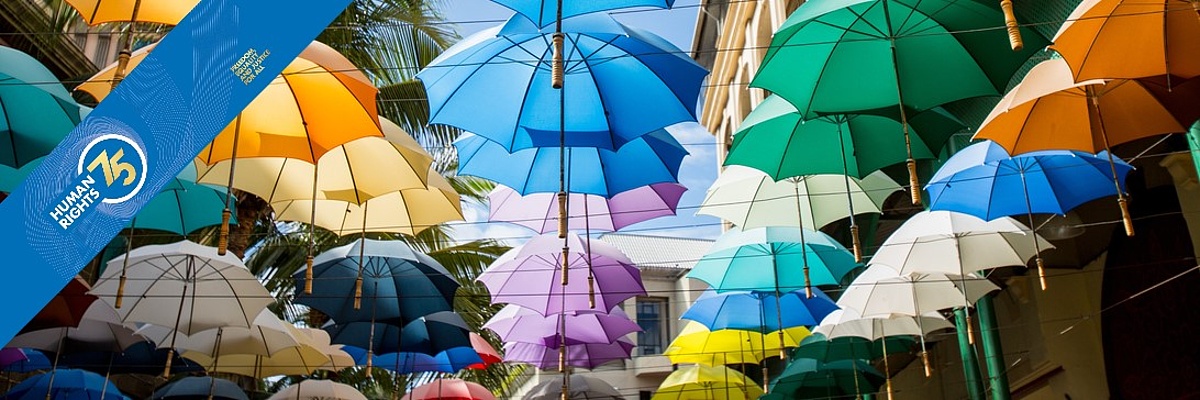 Eine Straße mit aufgehängten bunten Regenschirmen