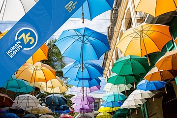 Eine Straße mit aufgehängten bunten Schirmen
