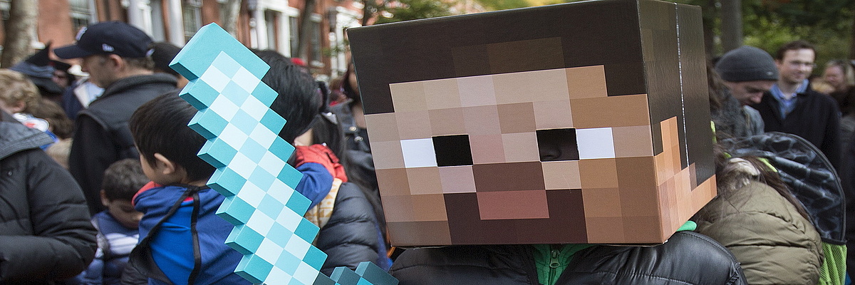 Junger Mensch mit Minecraft Pappschwert und Pappkopf beteiligt sich an einer Demonstration.