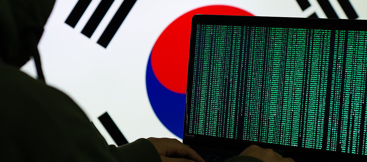Laptop mit grüner Schrift, Südkorea Flagge im Hintergrund