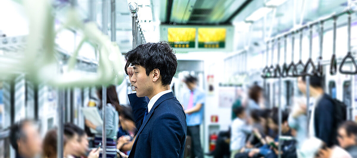 Asiatischer Mann in Anzug in der U-Bahn