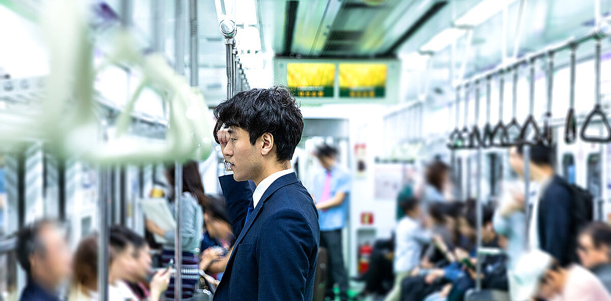 Asiatischer Mann in Anzug in der U-Bahn