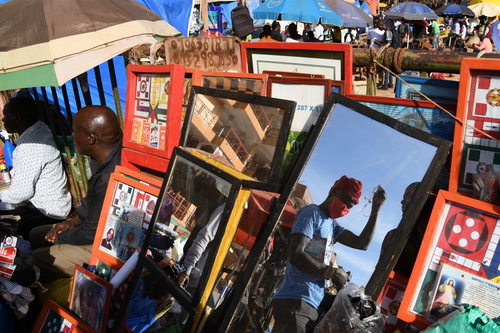 Mann mit Coronamaske in einem Spiegel auf einem Markt