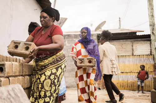 Afrikanische Frauen in traditioneller Kleidung bei der Arbeit.