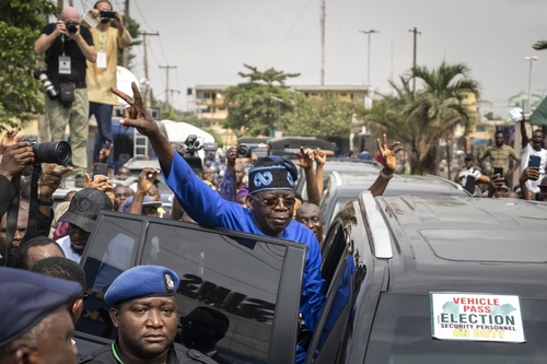 Präsidentschaftskandidat Bola Tinubu vom All Progressives Congress zeigt seinen Unterstützer:innen in Lagos (Nigeria) das Victory-Zeichen
