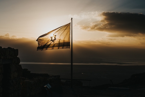 Israelische Flagge weht im Wind während des Sonnenuntergangs