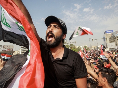 Protestierender Mann mit irakischer Flagge bei Protesten im Irak