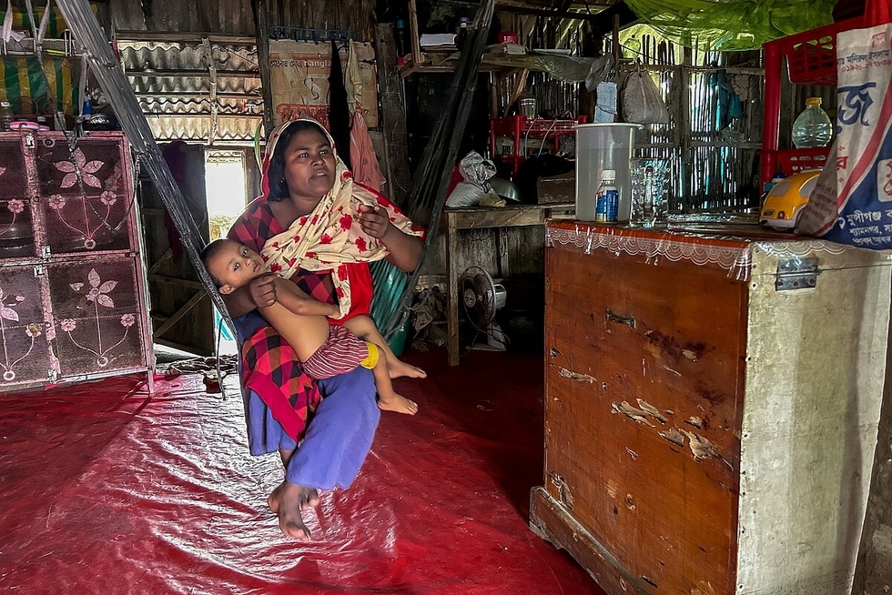 Auf dem Bild sieht man Rahima, eine Frau aus Bangladesh auf einer Hängematte in einer einfachen Hütte sitzen
