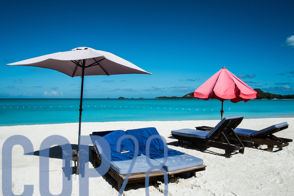 Karibische Aussicht aufs Meer mit Liegestühlen und Sonnenschirmen