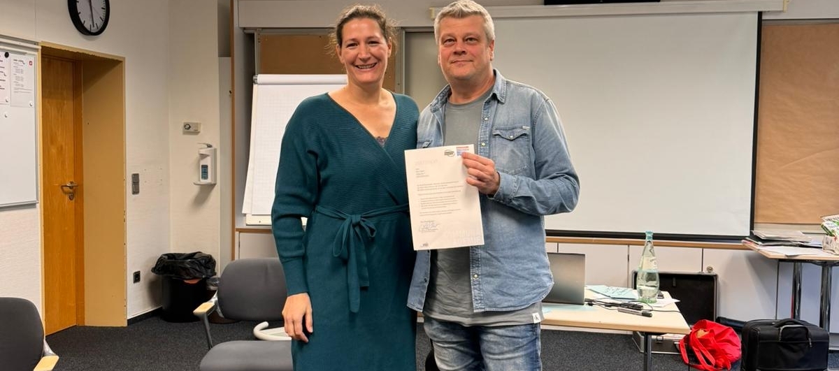 Marco Fladrich erhält sein Zertifikat von Anne Haller
