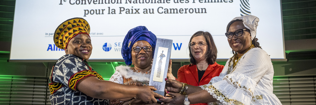 Sally Mboumien, Marthe Wandou, Esther Omam nehmen stellvertretend für die Frauenfriedensplattform Kamerun den Deutschen Afrika-Preis 2023 entgegen und halten die Skulptur hoch. 