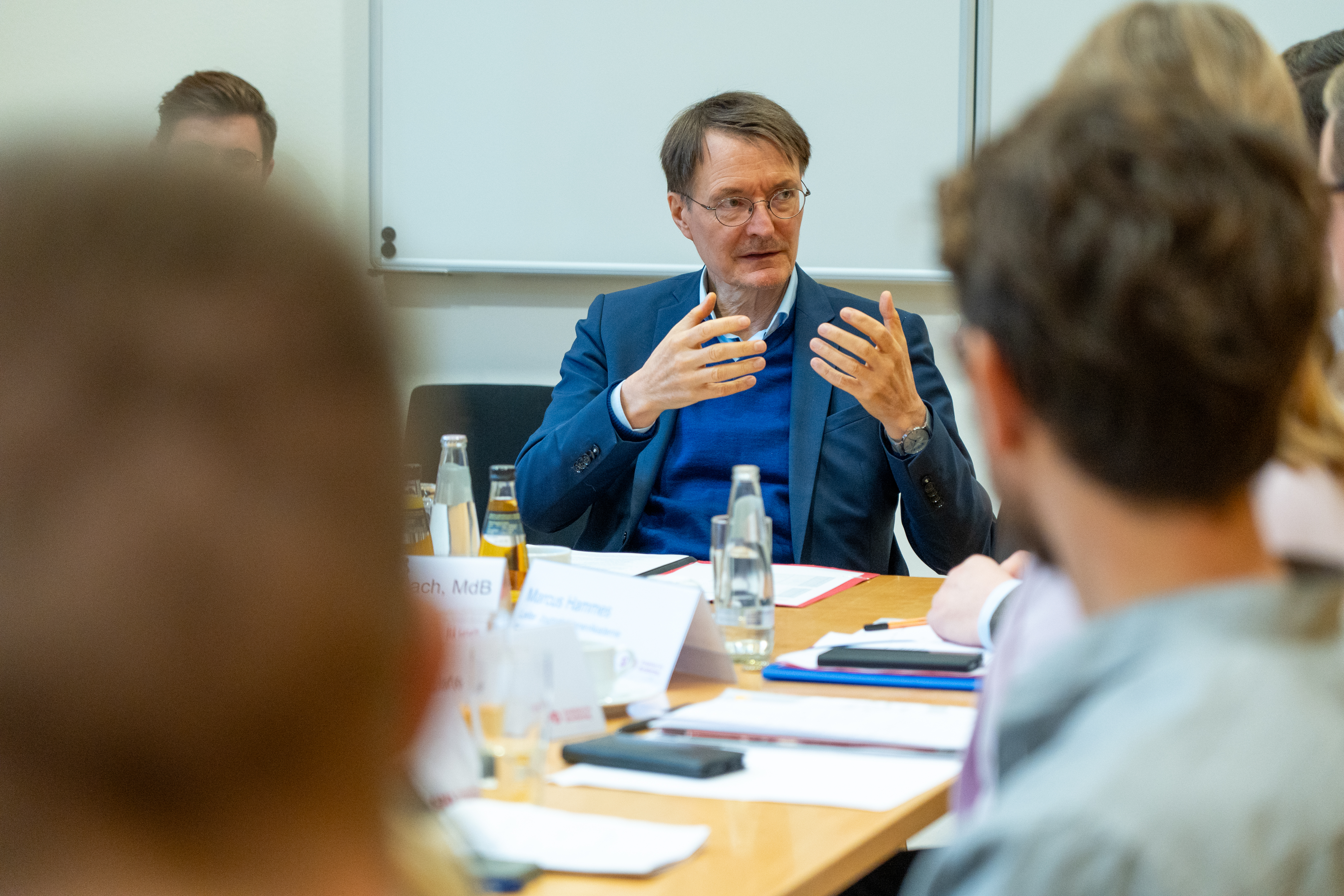 Prof. Dr. Karl Lauterbach diskutiert mit den Teilnehmenden an einem Tisch.