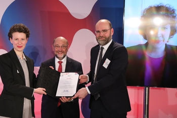 Martin Schulz überreicht stelltvertretend die Urkunde des Hans-Matthöfer-Preises für Isabella Weber an Mitarbeitende des Suhrkamp-Verlags