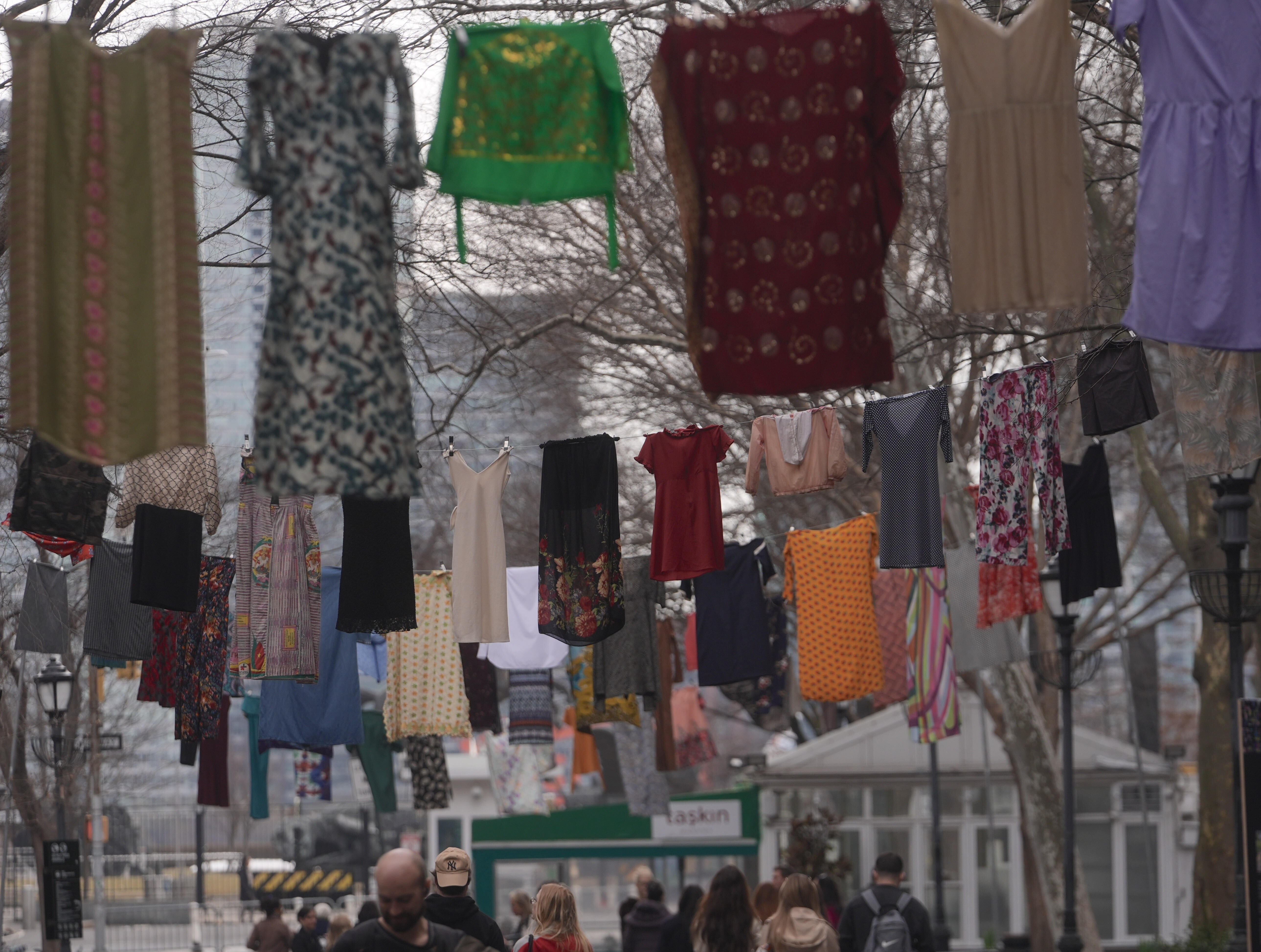Wäscheleinen mit Kleidung hängen über einer Fußgängerstraße in New York. Das ist die öffentliche Kunstinstallation "Thinking of You" der Konzeptkünstlerin Alketa Xhafa Mripa aus dem Kosovo, die den Überlebenden sexueller Gewalt gewidmet ist.