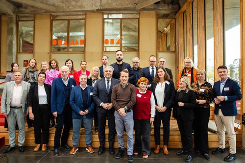 Foto einer Gruppe vpn Kommunalpolitiker*innen in einer Veranstaltungshalle