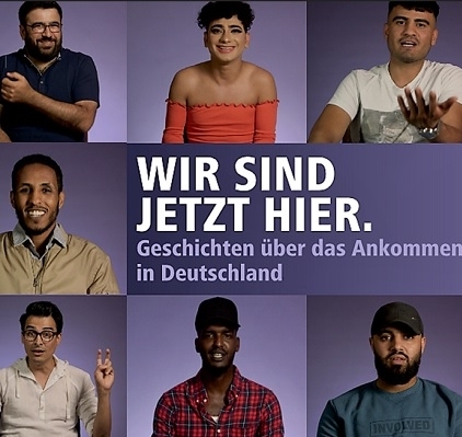 Eine Collage mit acht Menschen unterschiedlicher Herkunft, die in die Kamera blicken. In der Mitte steht der Schriftzug: „WIR SIND JETZT HIER. Geschichten über das Ankommen in Deutschland“ auf lila Hintergrund.