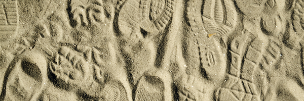 Vorschaubild mit verschiedenen Schuhabdrücken im Sand