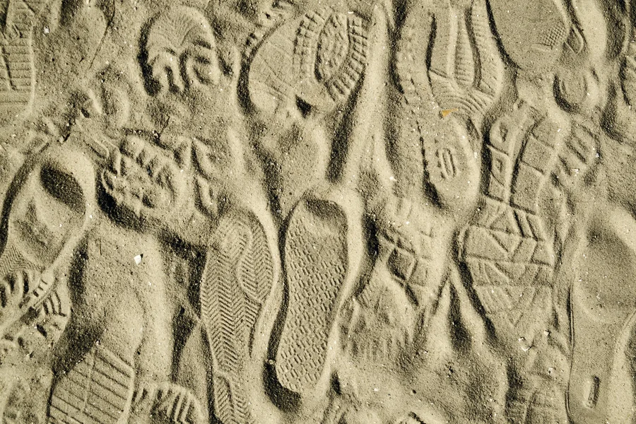 Vorschaubild mit verschiedenen Schuhabdrücken im Sand