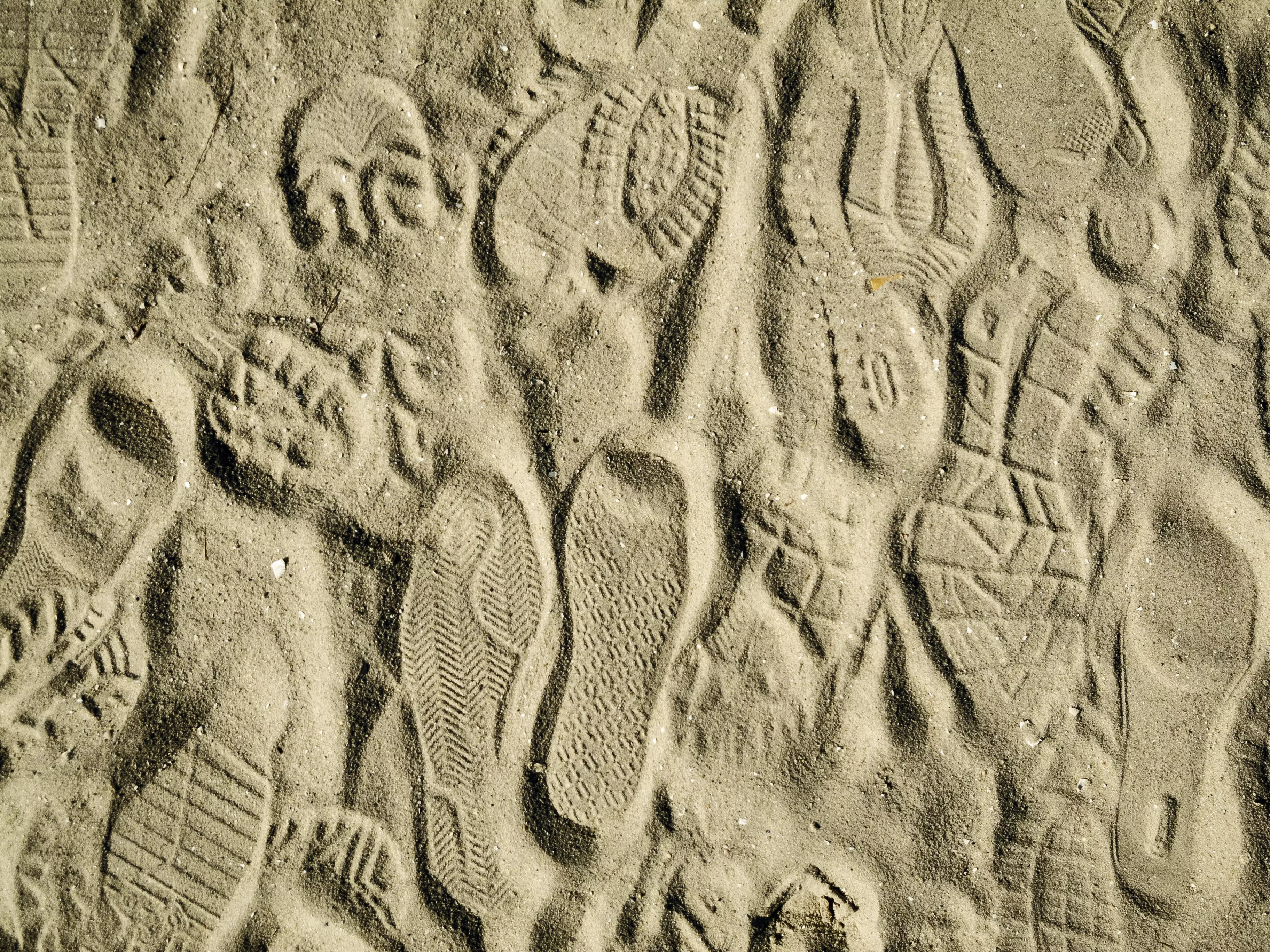 Vorschaubild mit verschiedenen Schuhabdrücken im Sand