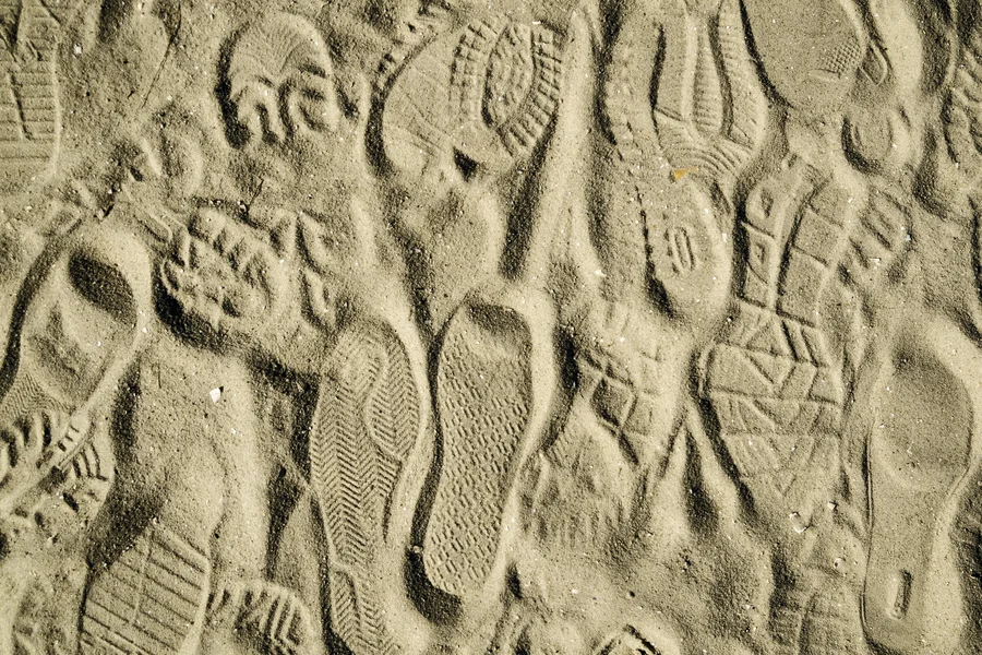 Vorschaubild mit verschiedenen Schuhabdrücken im Sand